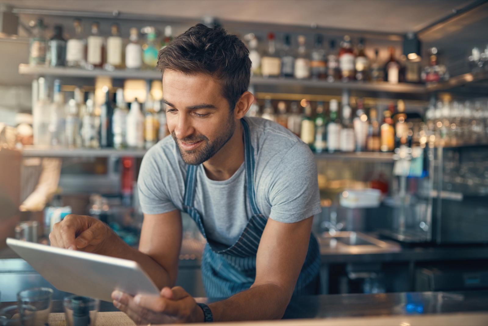 A bar owner checking orders on a tablet