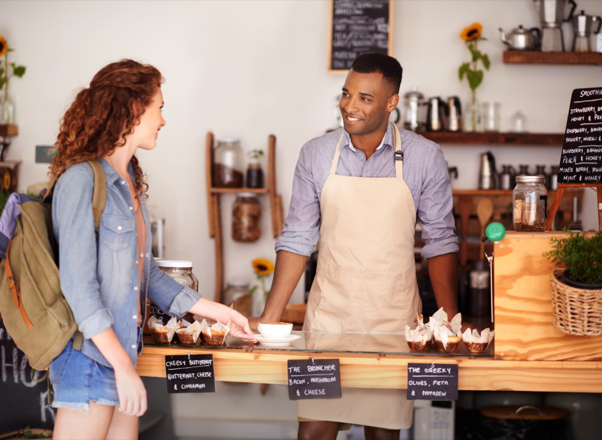 A shop owner serving a customer at the counter